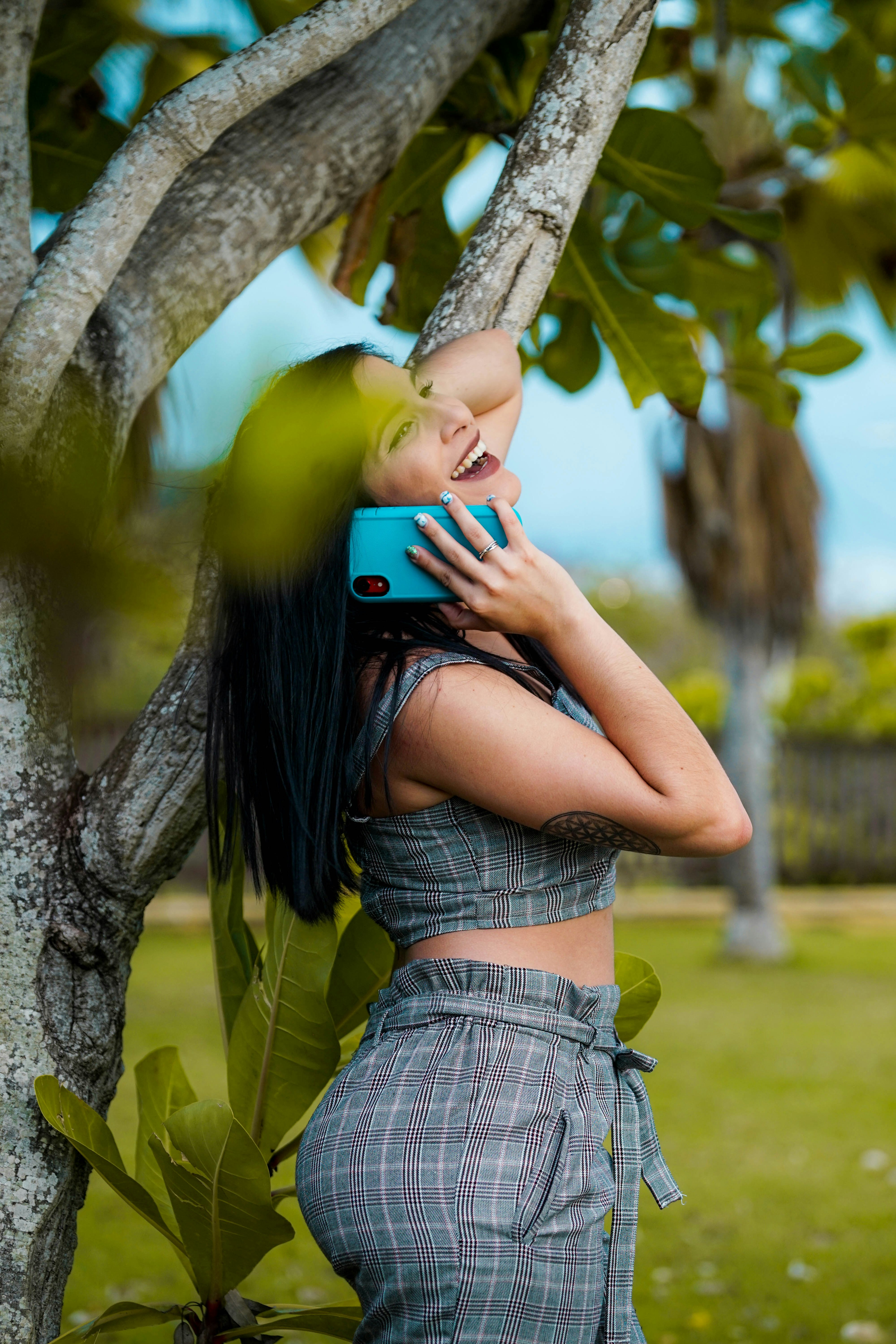 woman listing on to blue smartphone